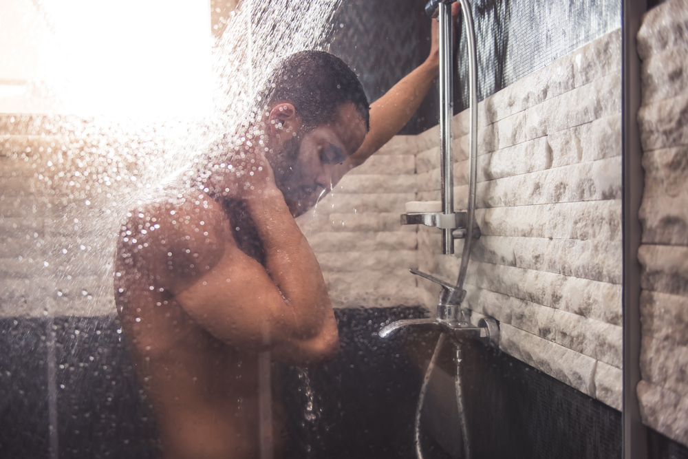 sexy man in shower using penis pump