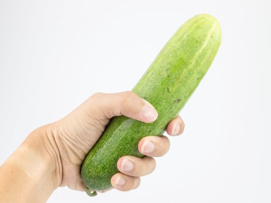 Cucumber in hand isolated on white background
