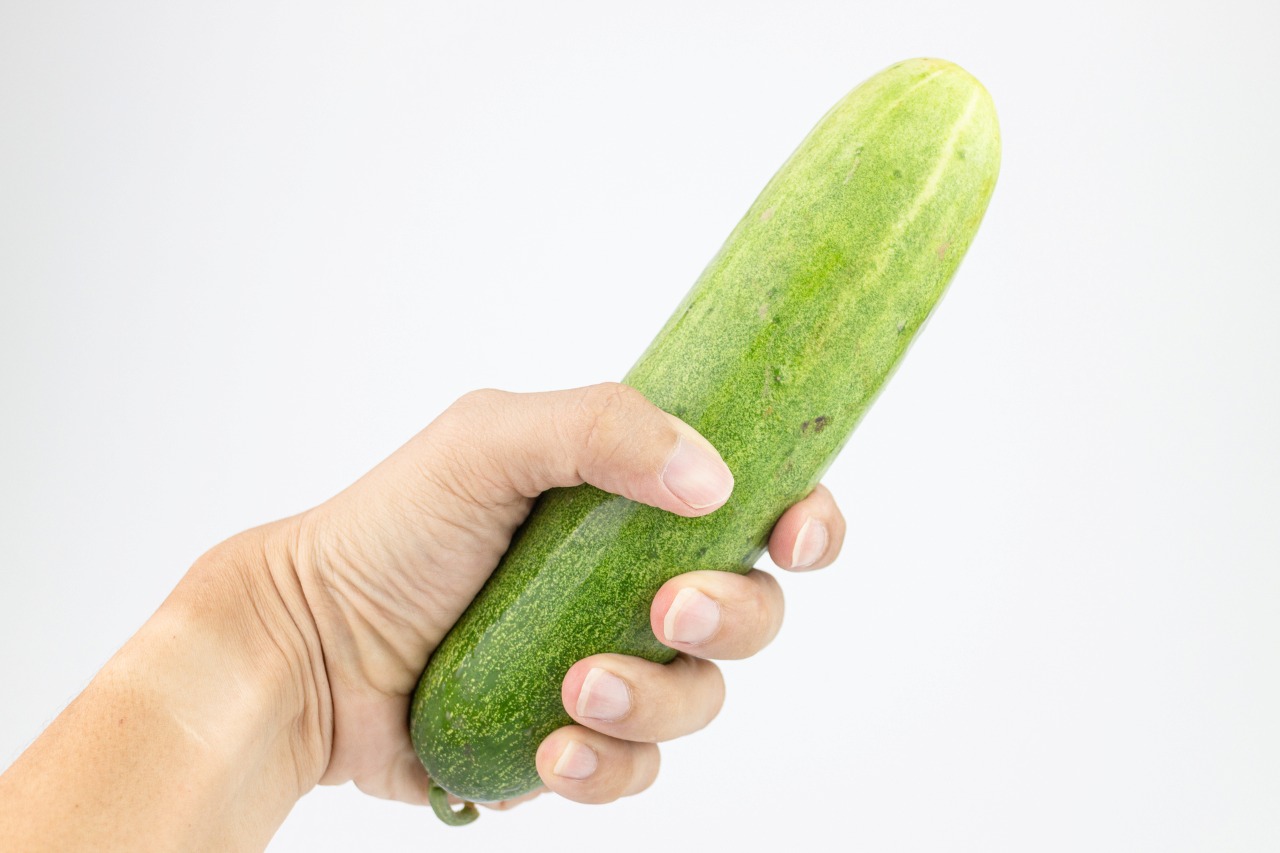 Cucumber in hand isolated on white background