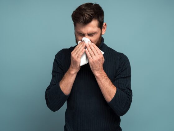 man covering his nose because of allergy