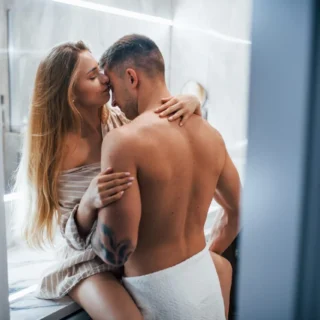 Young couple embracing and kissing each other in the bathroom