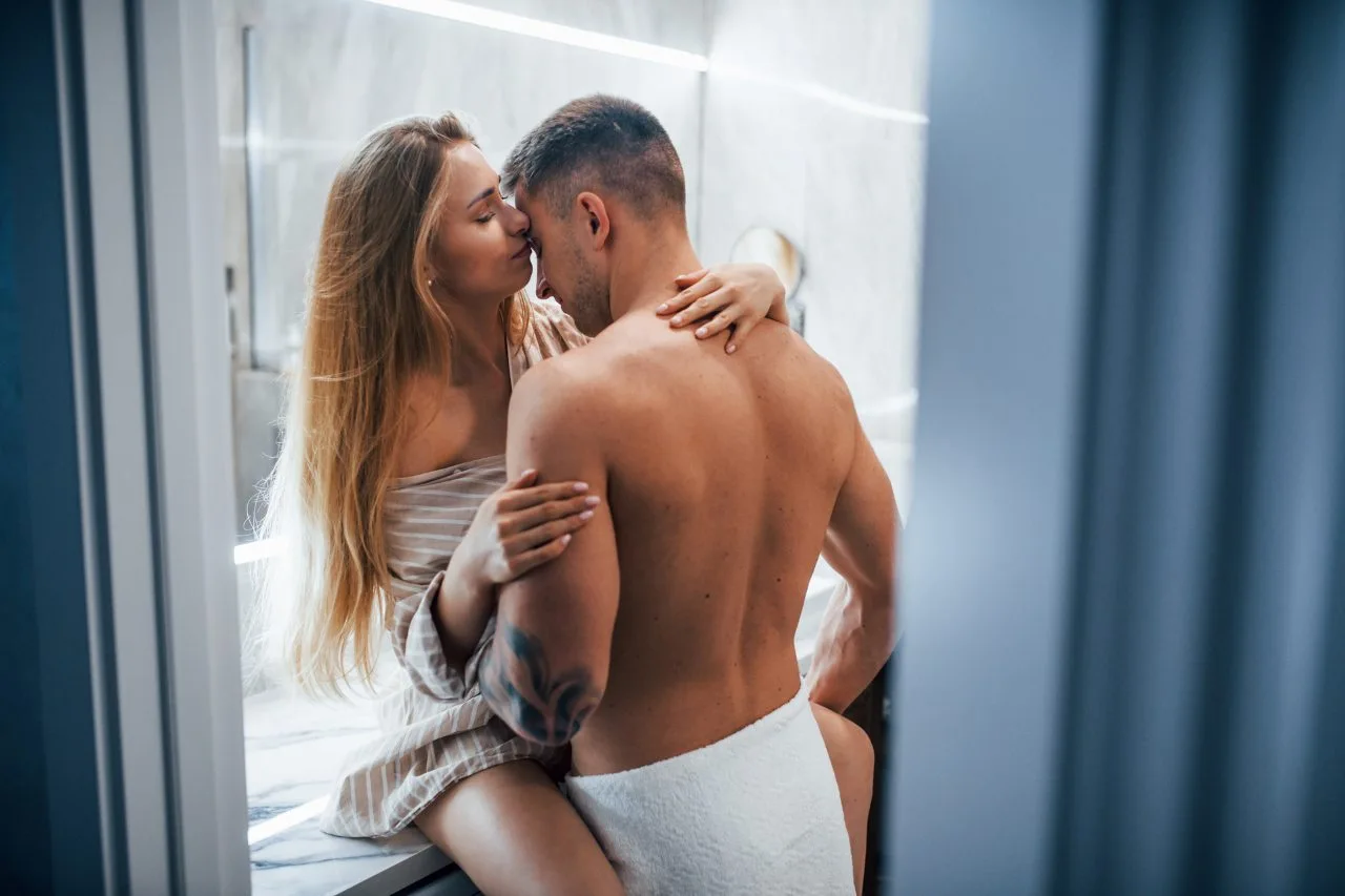 Young couple embracing and kissing each other in the bathroom